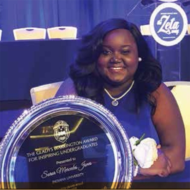 Woman in purple holds award